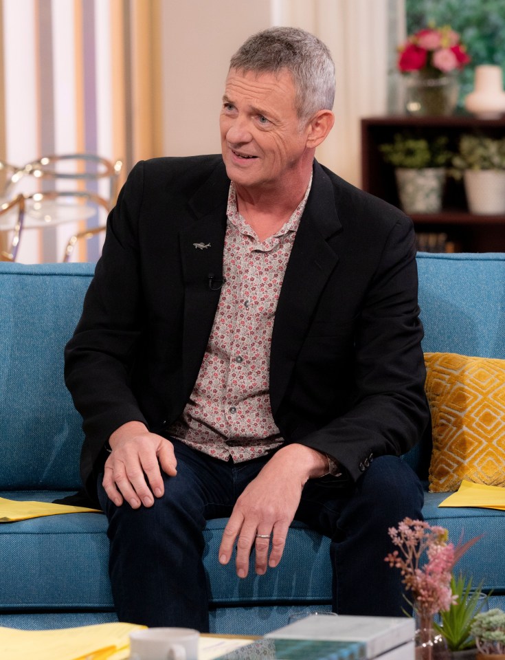 a man in a suit is sitting on a blue couch
