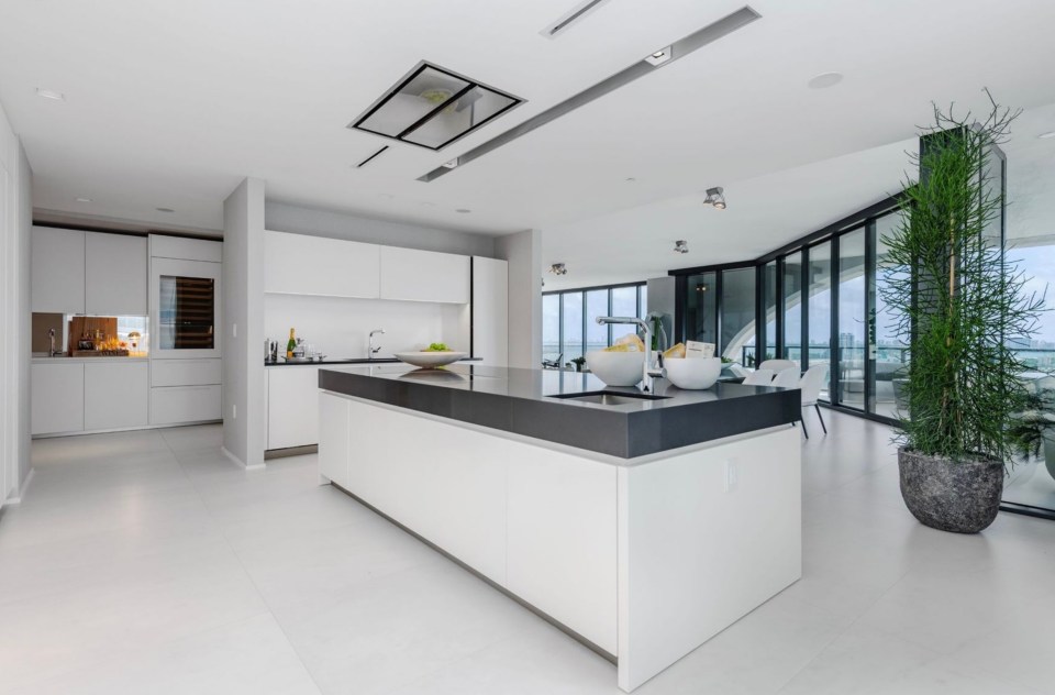 a kitchen with a black counter top and white cabinets