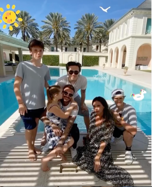 a family posing for a picture in front of a swimming pool