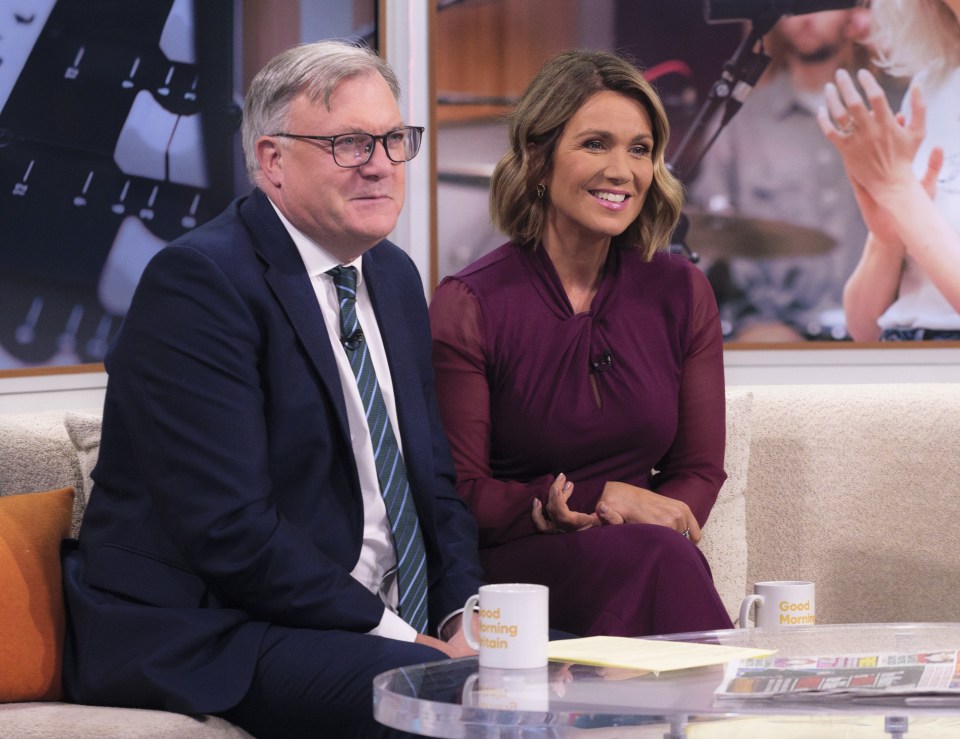 a man and a woman sit on a couch with a mug that says good morning today