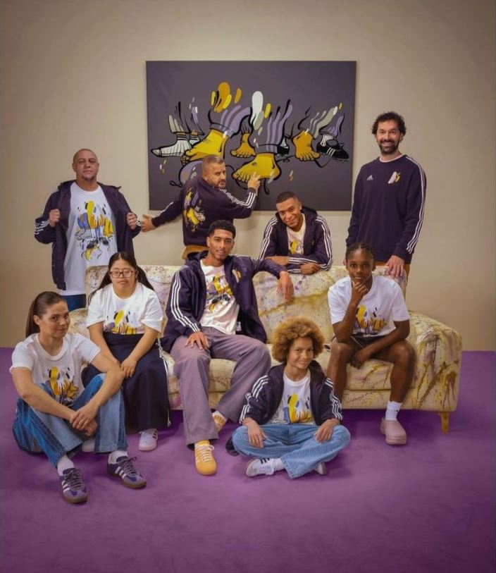 a group of people sitting on a couch wearing adidas shirts