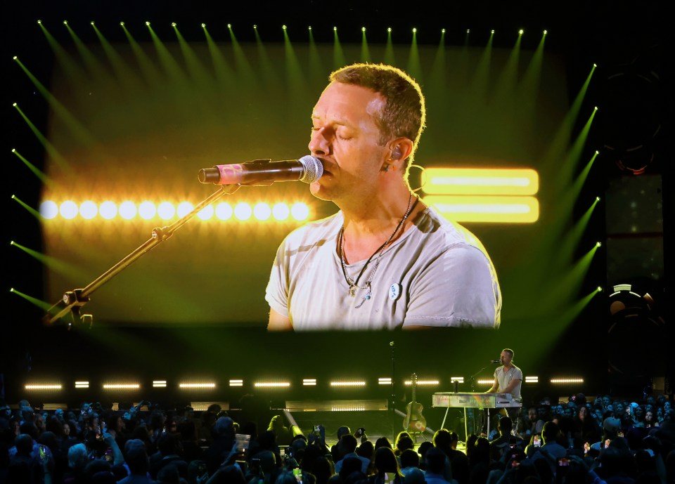 a man singing into a microphone on a stage