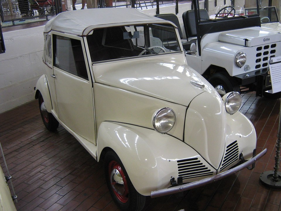 an old white car with a white roof is on display