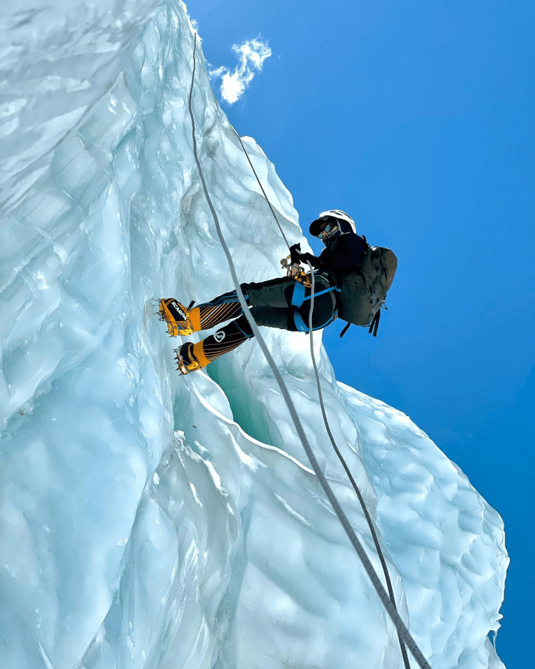 a group of people standing on top of a snow covered mountain