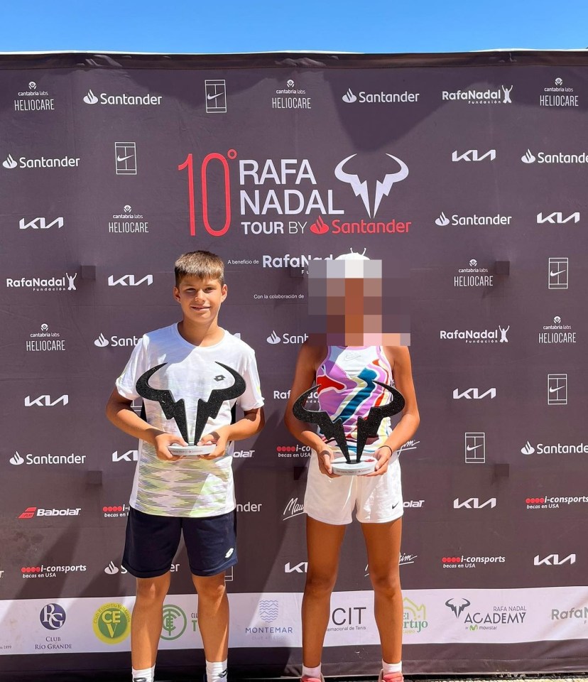 two people holding trophies in front of a banner that says rafa nadal tour by santander