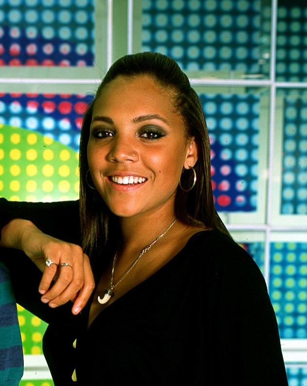a man and a woman are posing for a picture in front of a colorful wall