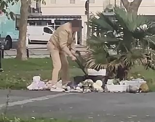 a man is picking up trash on the side of the road