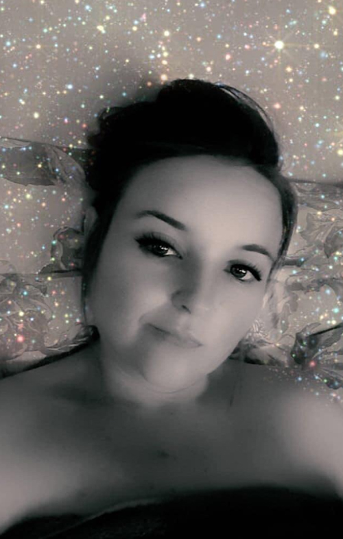 a woman laying on a bed with a bun in her hair