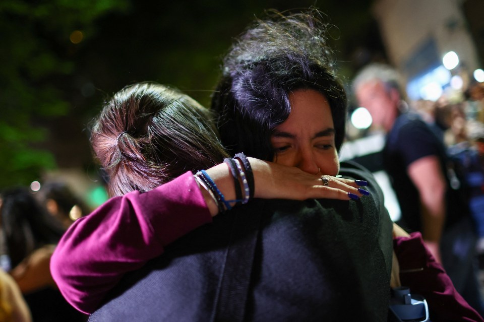 a woman with a ring on her finger is hugging another woman