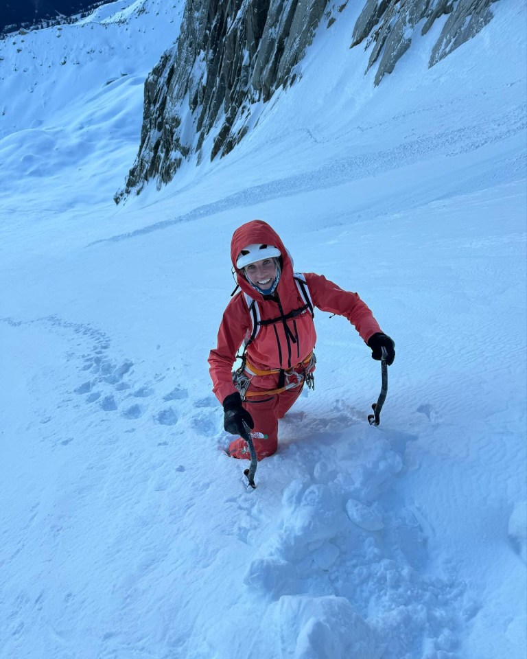 a person in a red jacket is kneeling in the snow