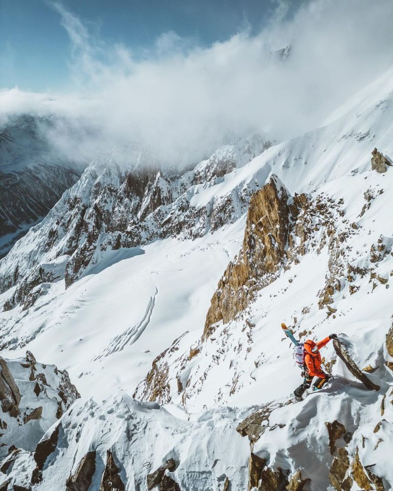 a person standing on top of a snow covered mountain