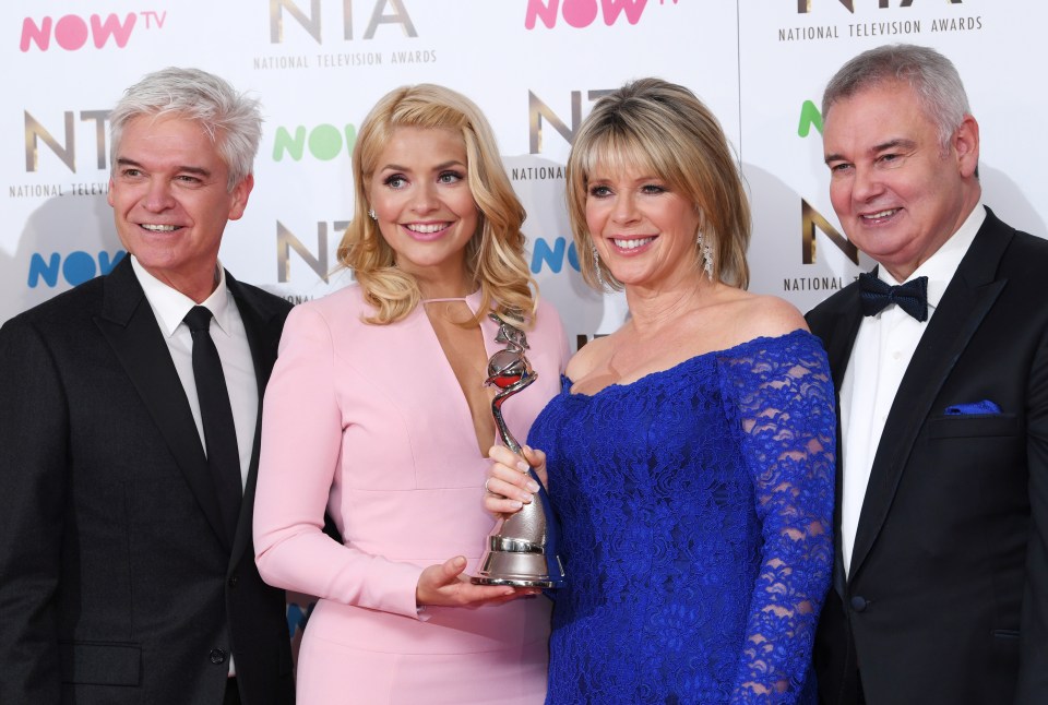 a group of people standing in front of a now tv sign