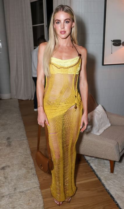 a woman in a yellow dress is standing in a room .