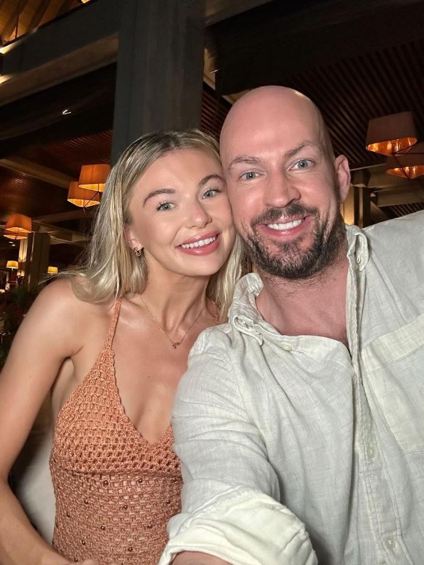 a bald man and a blonde woman are posing for a picture