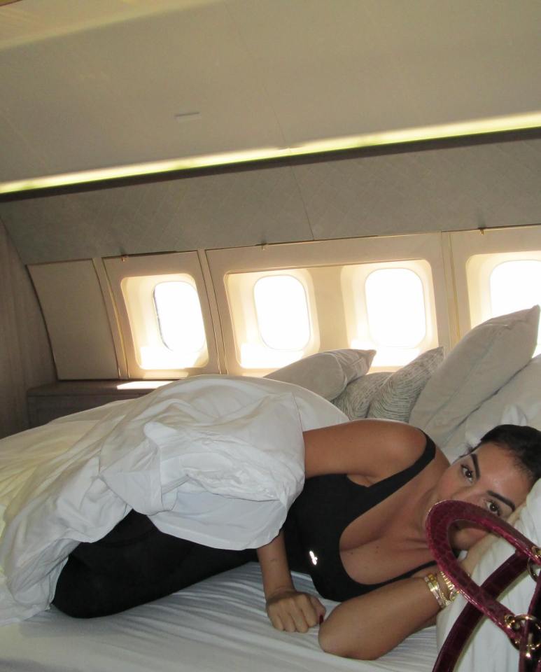 a woman is laying on a bed in an airplane