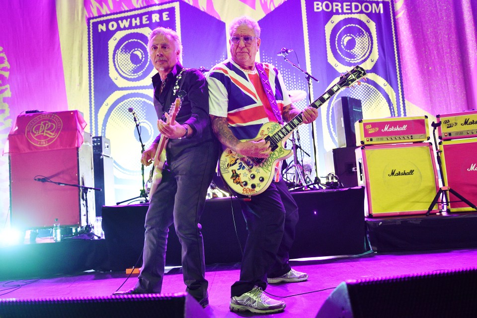 two men playing guitars in front of a banner that says nowhere and boredom