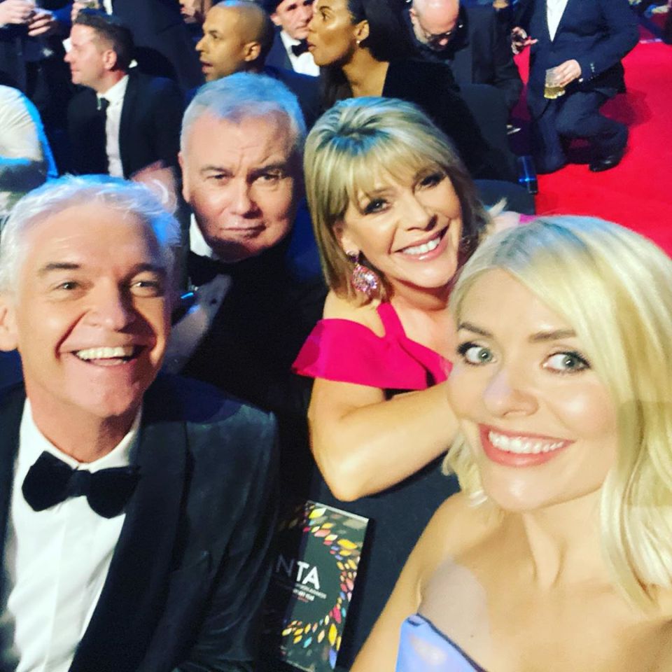 a group of people posing for a picture with a nta sign in the background