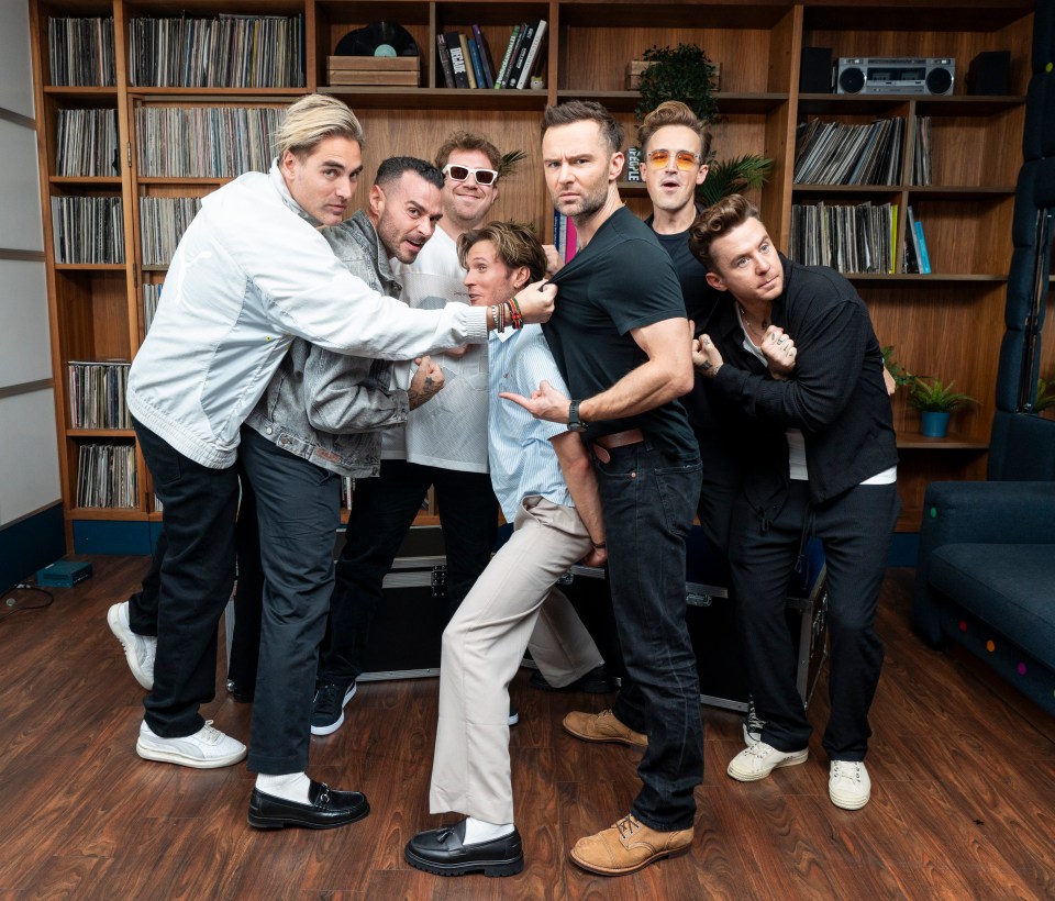 a group of men are posing for a picture and one of them is wearing sunglasses