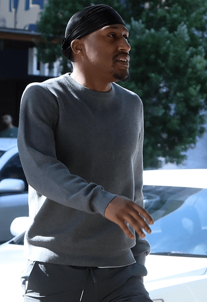 a man wearing a black headband and a grey sweater