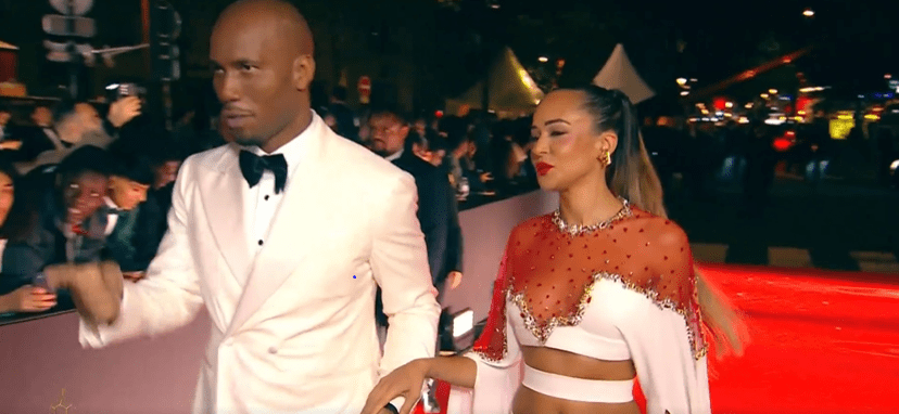 a man and a woman are walking on a red carpet