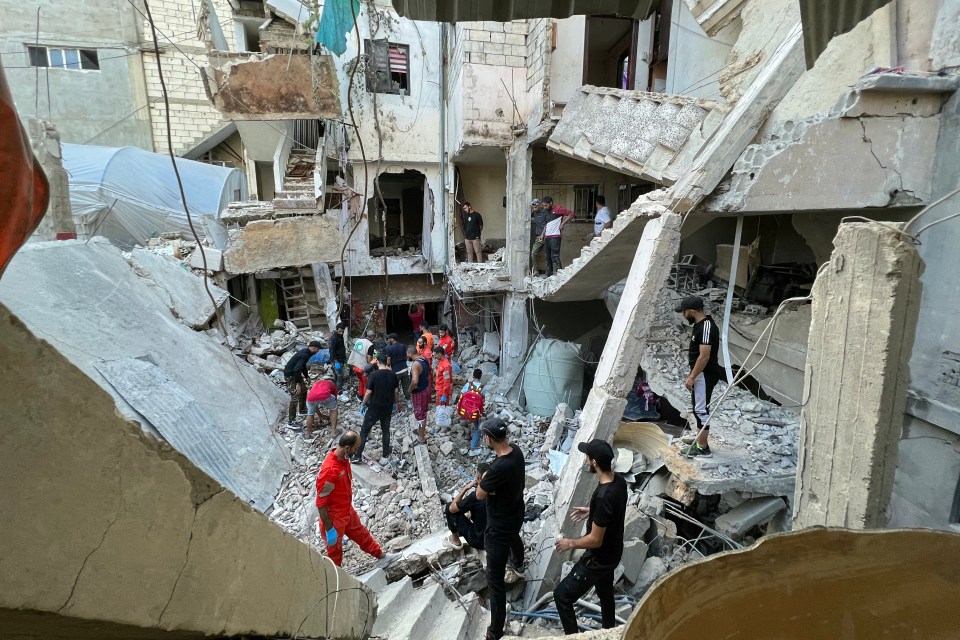 a group of people are standing in the rubble of a building