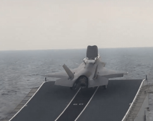 a fighter jet is taking off from the deck of a ship