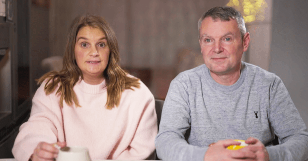 a woman in a pink sweater sits next to a man in a grey sweater