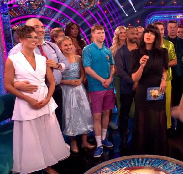 a group of people standing in front of a spinning wheel