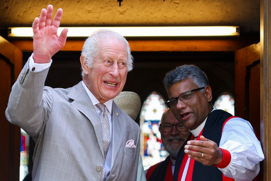 a man in a suit and tie is waving at the camera