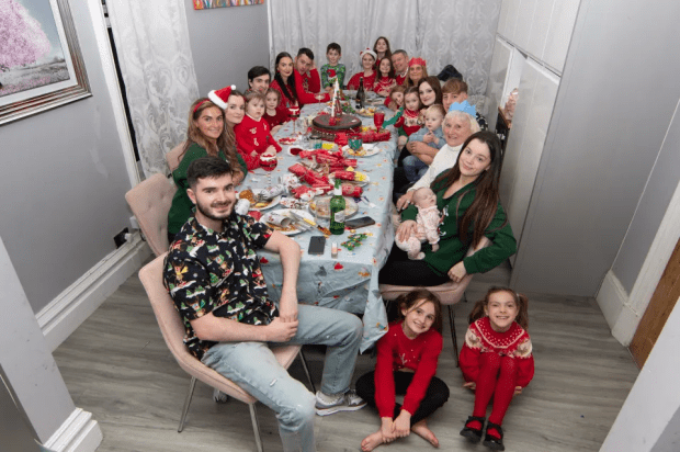 a group of people sitting around a table with a cake on it