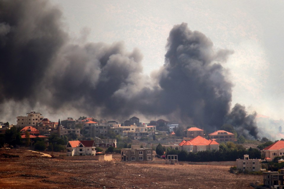 a large cloud of smoke rises over a residential area