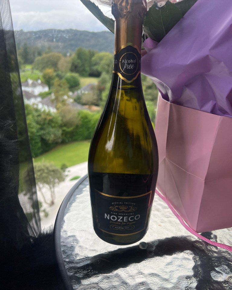 a bottle of nozeco wine sits on a glass table
