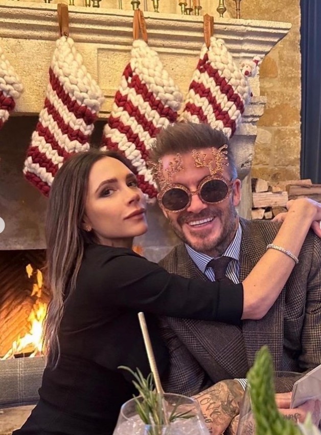 a man and woman are posing for a picture in front of a fireplace