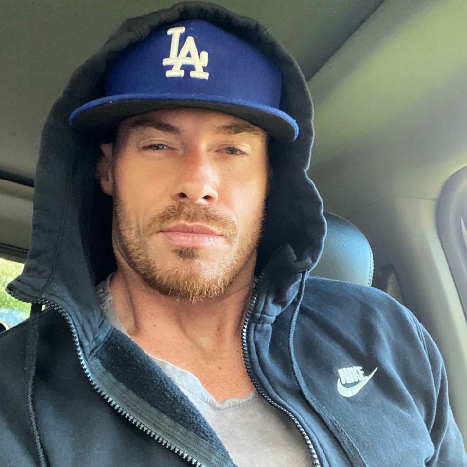 a man wearing a la hat and a nike jacket