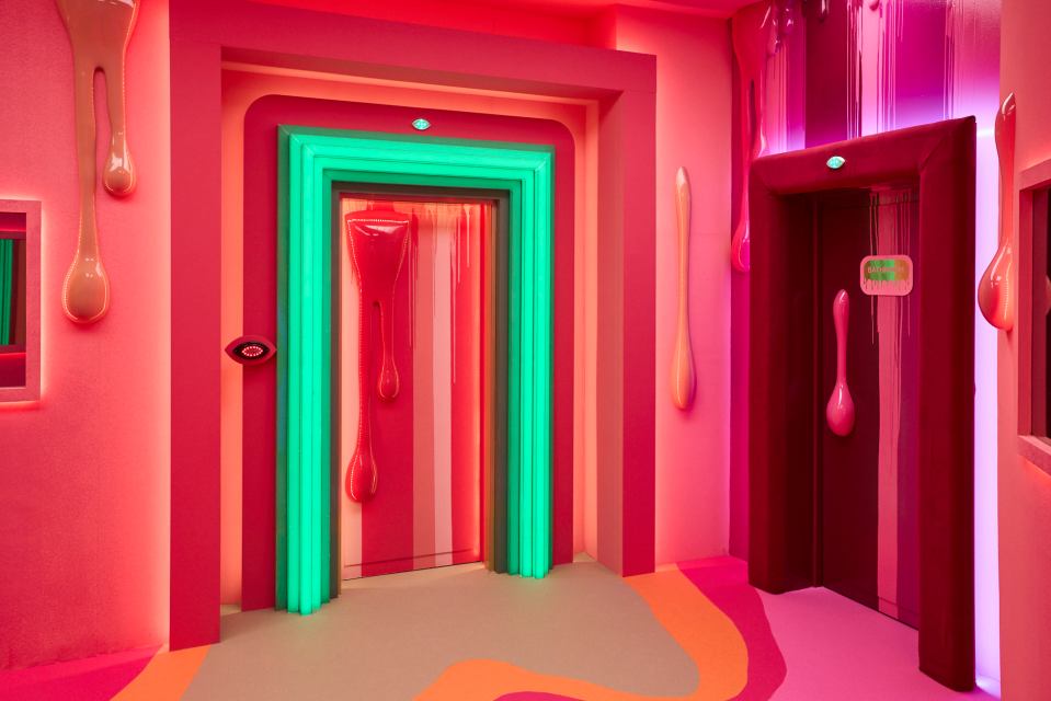 a pink room with a green exit sign