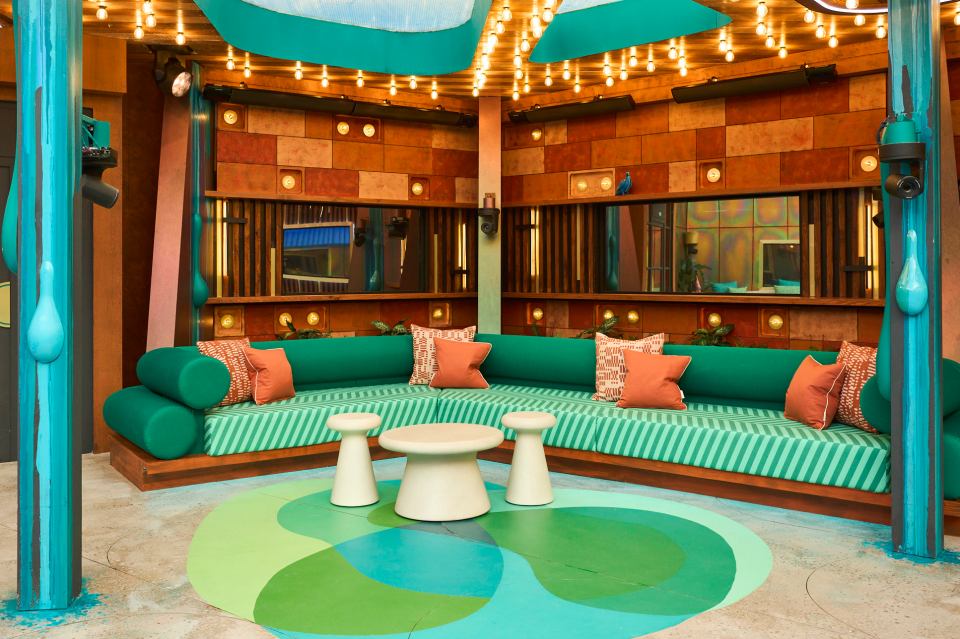 a room with a green couch and white tables