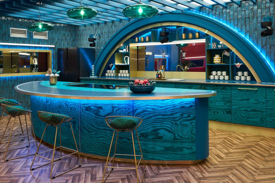 a kitchen with blue cabinets and a bowl of fruit on the counter