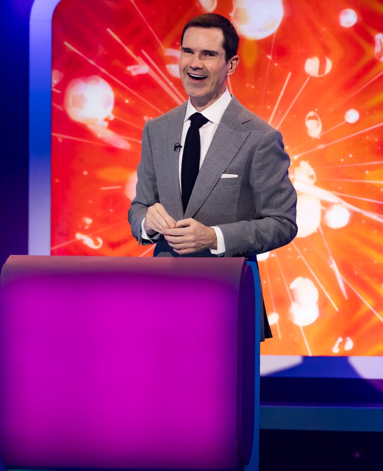 a man in a suit and tie stands behind a podium