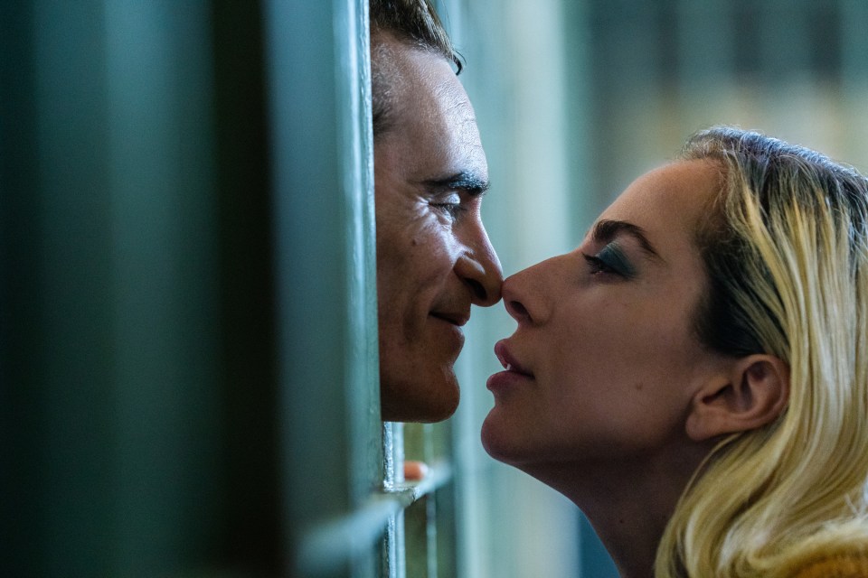 a man and a woman are touching noses behind bars