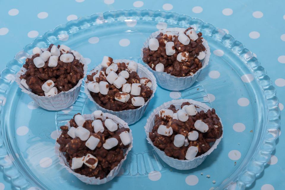 cupcakes with chocolate and marshmallows on a blue and white polka dot plate
