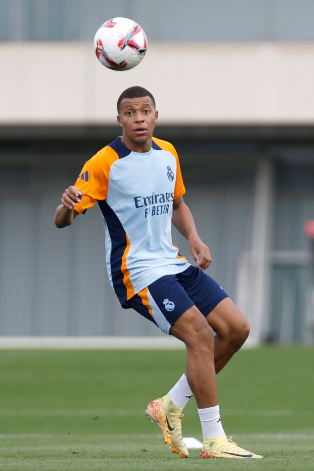 a soccer player wearing a shirt that says emirates fly better