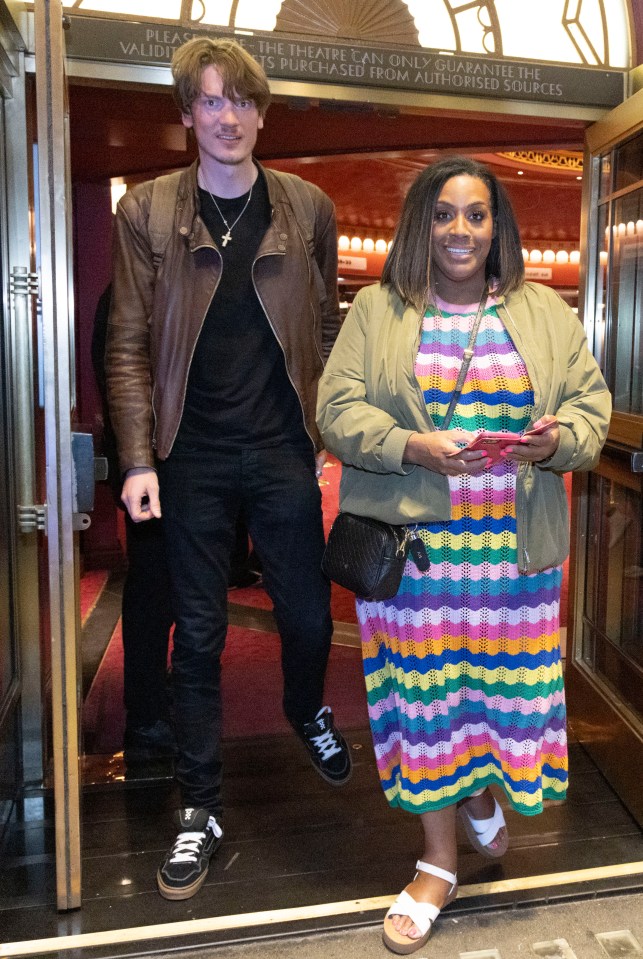 a woman in a striped dress stands next to a man in a leather jacket