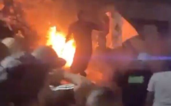 a crowd of people watching a fire in a dark room .