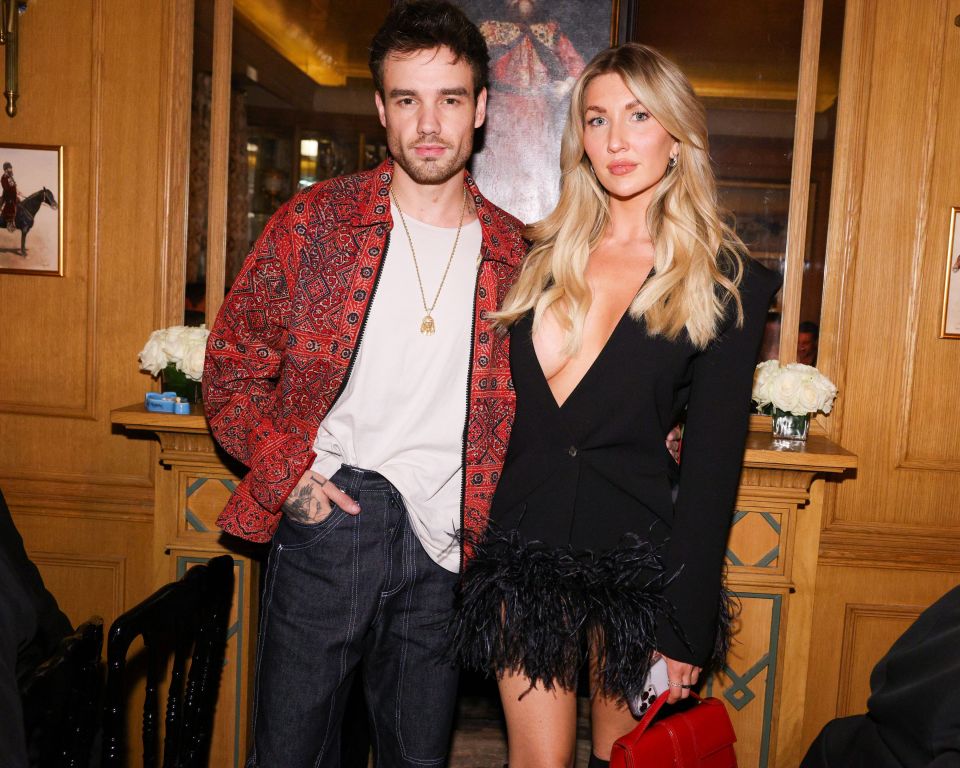 a man in a red jacket and a woman in a black dress pose for a picture