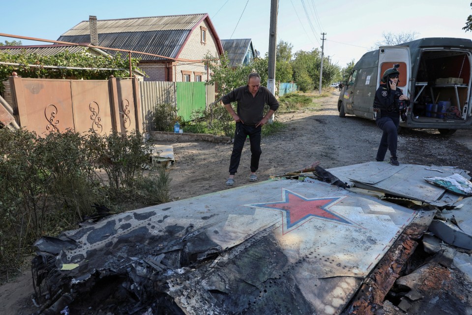 a man standing next to a plane wing with a red star on it