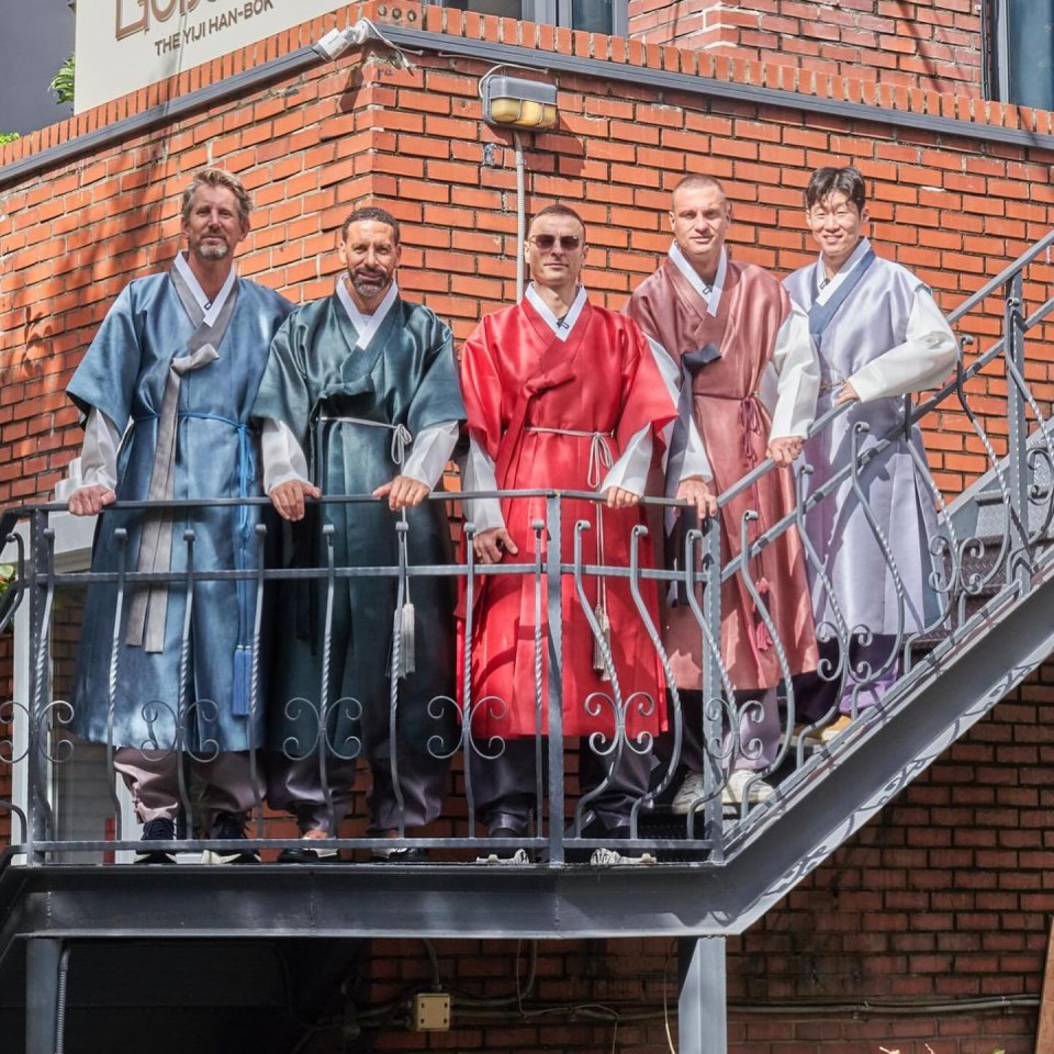 a group of men standing on a set of stairs in front of a building that says the full han-bok