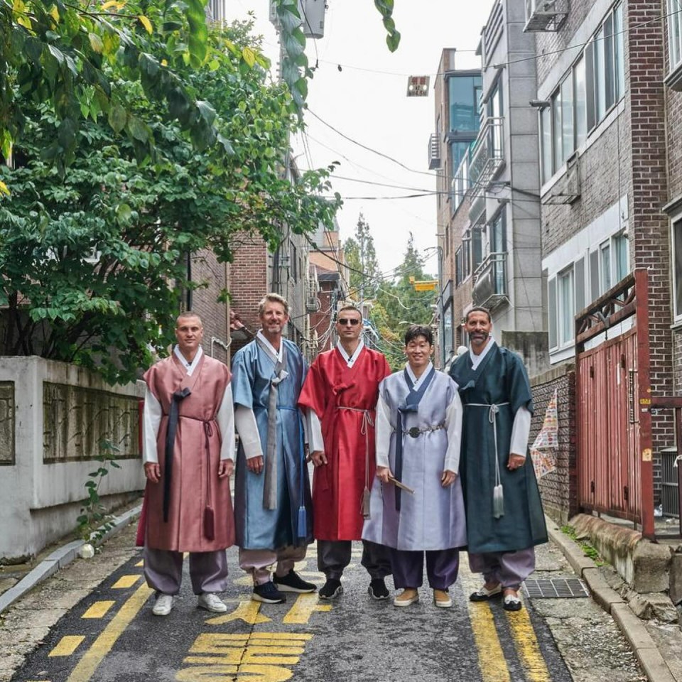 a group of people standing on a street with a yellow line that says ' seoul ' on it