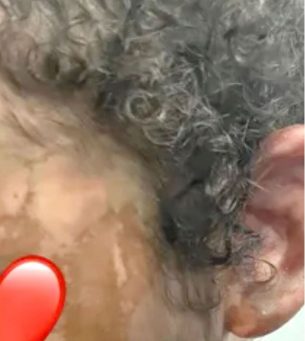a close up of a person 's ear with a red heart next to it .