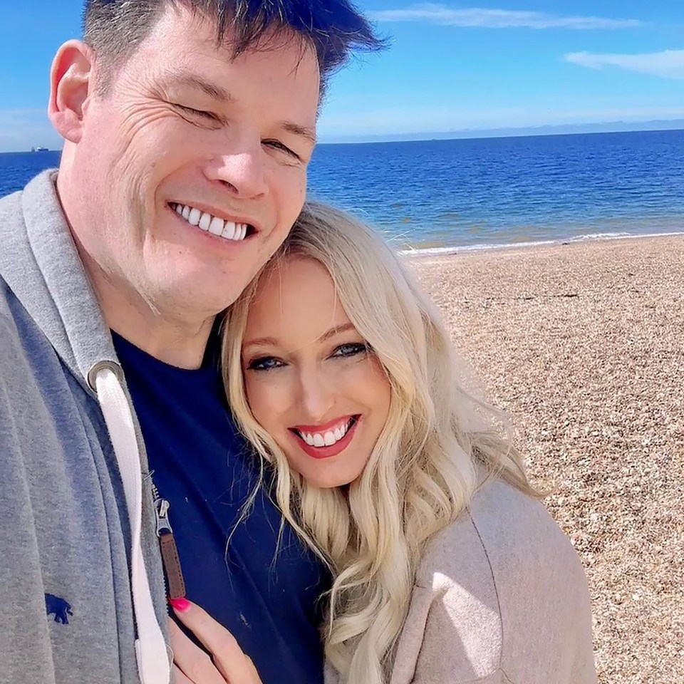 a man and a woman are posing for a picture on the beach