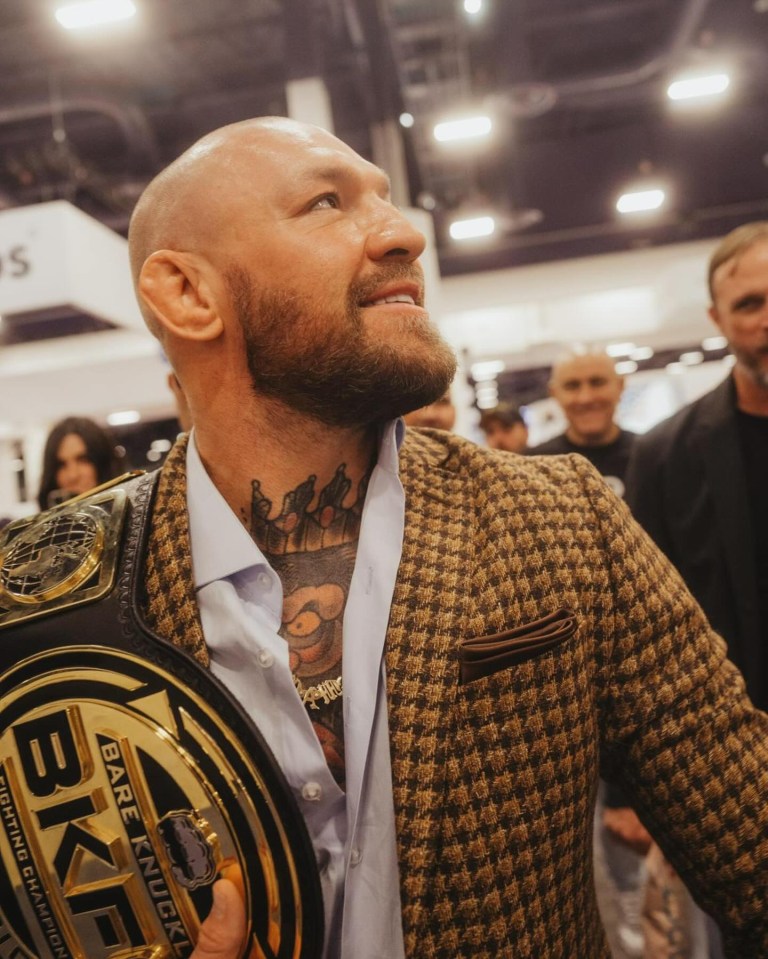 a man in a suit is holding a bag of ufc popcorn